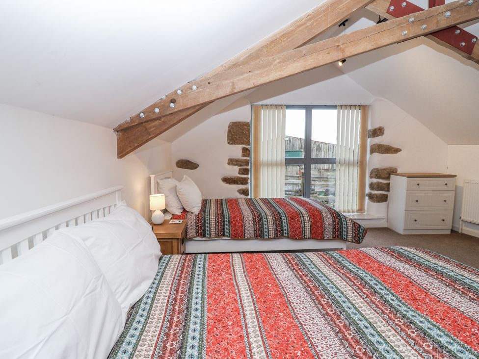 A bedroom with two beds and a window at Dairy Cottage Bullhornstone near South Brent