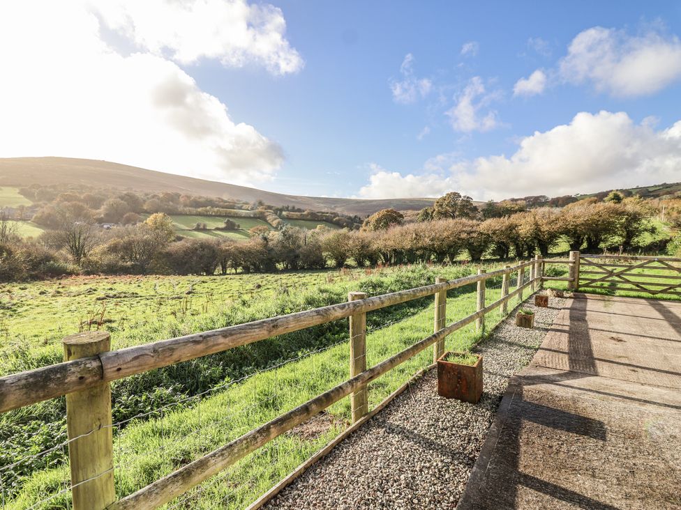 A view of hills and a grassy field with a fence at Dairy Cottage in Bullhornstone near South Brent