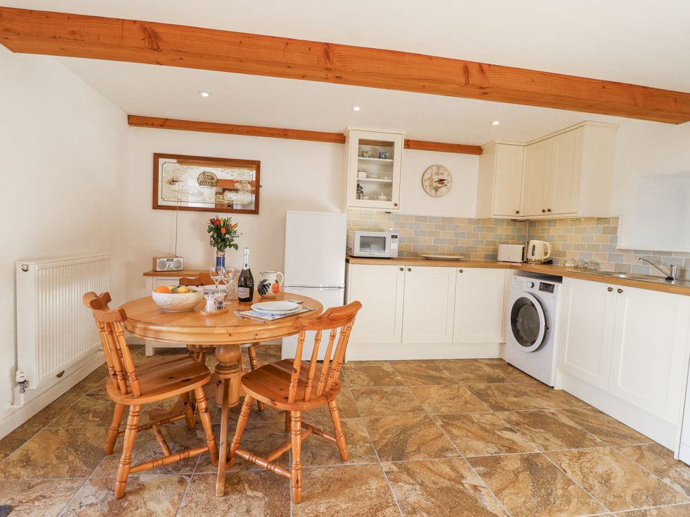 A kitchen with a table and chairs at Swallow Cottage Bullhornstone near South Brent