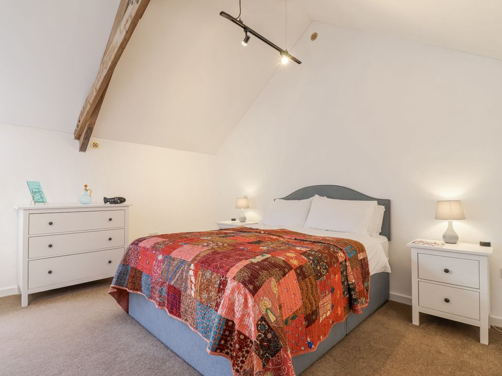 A bedroom with a bed and nightstands at Swallow Cottage Bullhornstone near South Brent