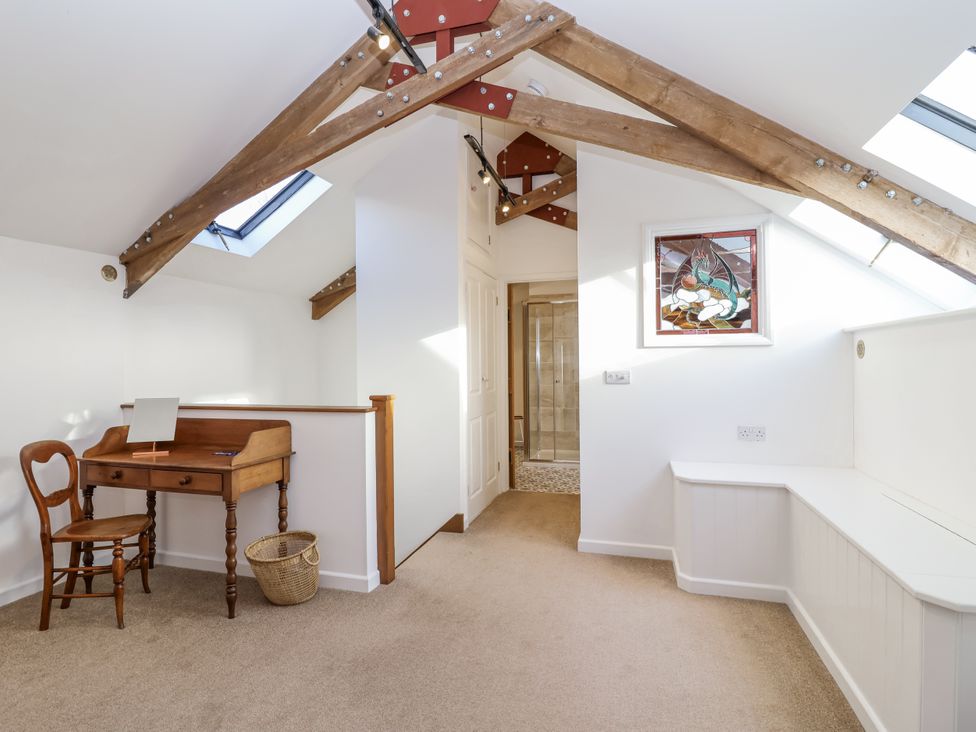 A loft space with a writing desk and chair at Swallow Cottage Bullhornstone near South Brent