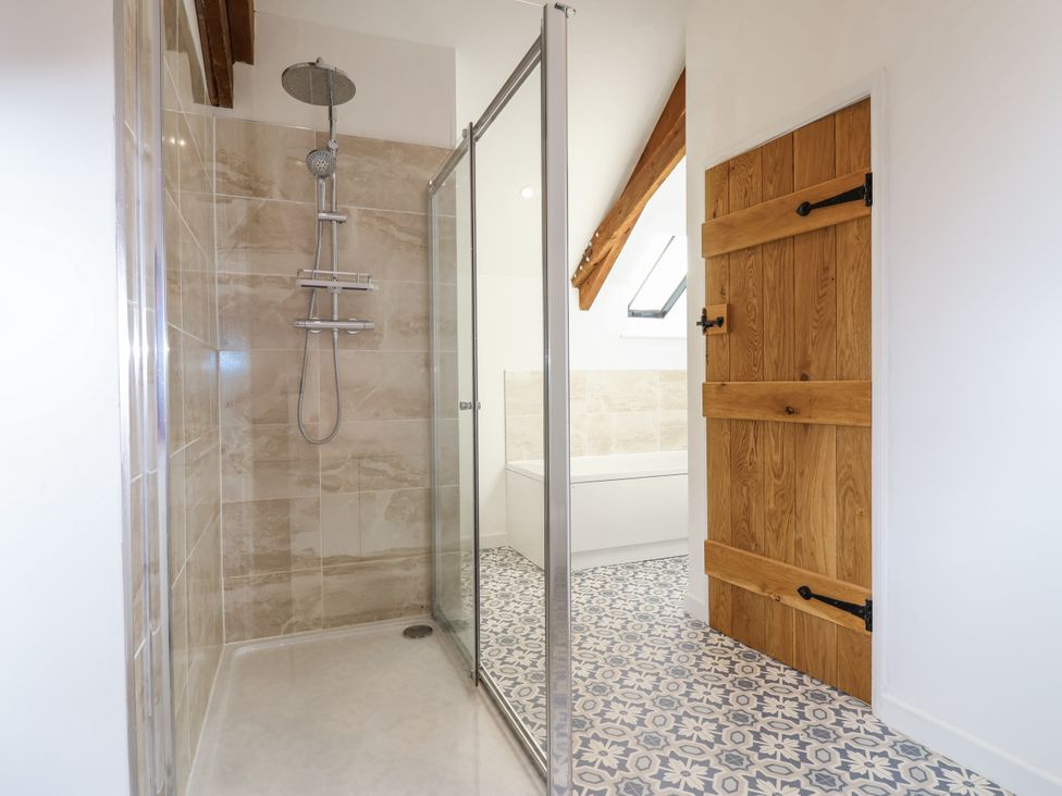 A bathroom with a shower and a bathtub at Swallow Cottage Bullhornstone near South Brent