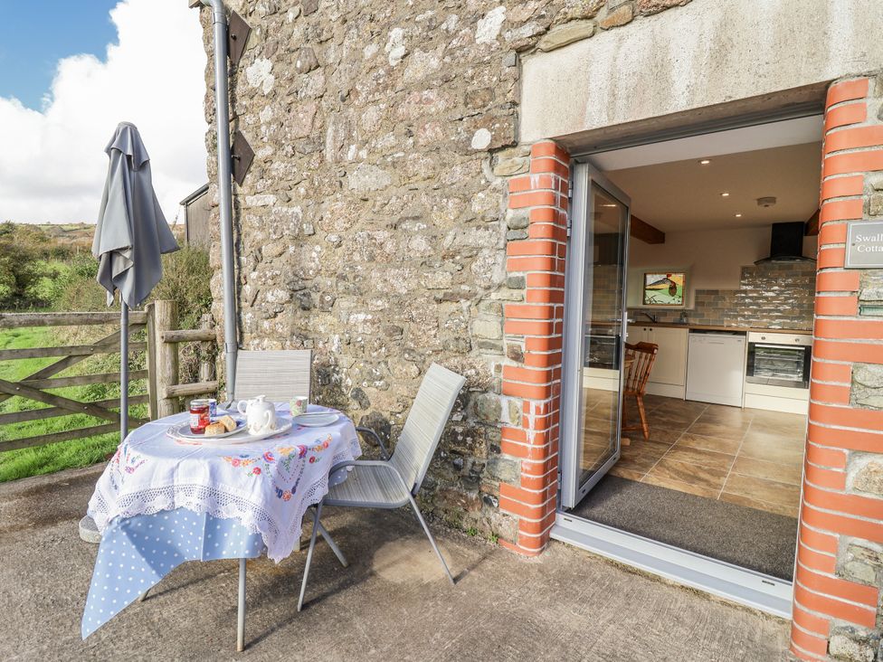 An outdoor patio with table set for tea at Swallow Cottage Bullhornstone near South Brent