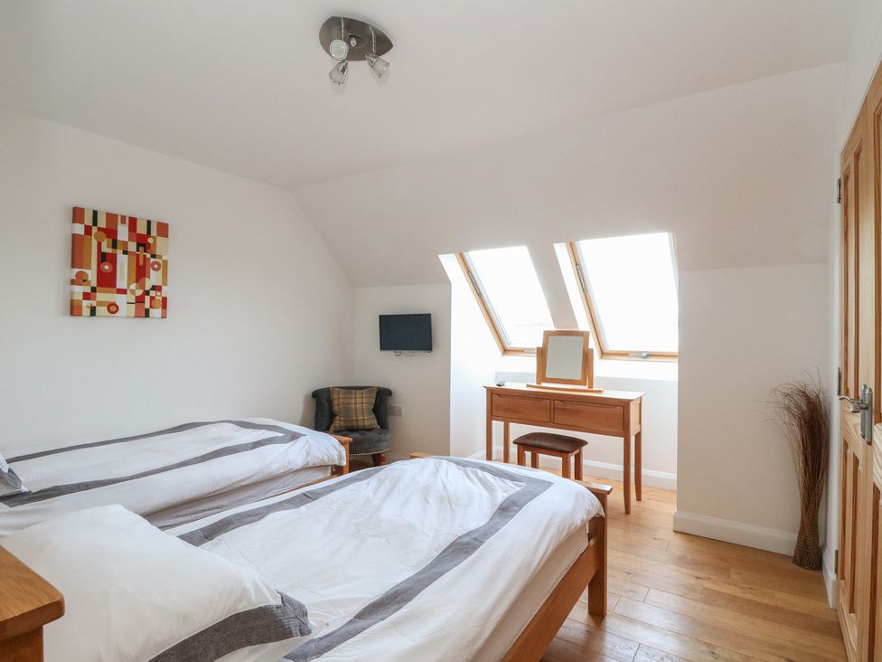 A bedroom with two beds and a table at Lurach House in Port Appin