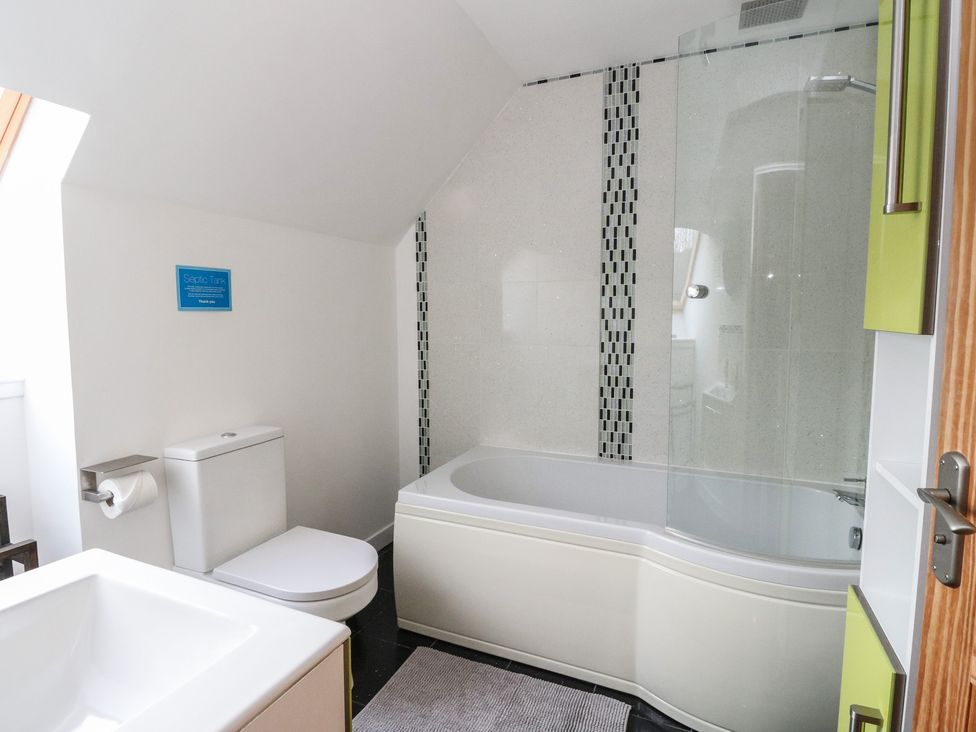 A bathroom with a bathtub and toilet at Lurach House Port Appin