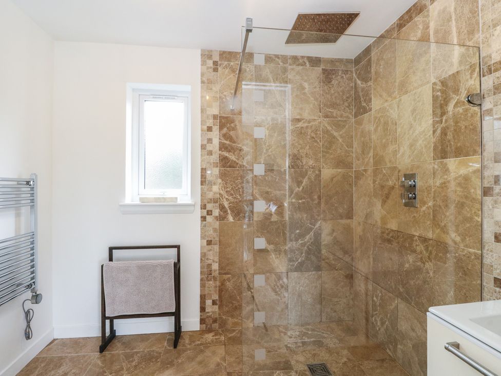A bathroom with shower and towel rack at Lurach House in Port Appin