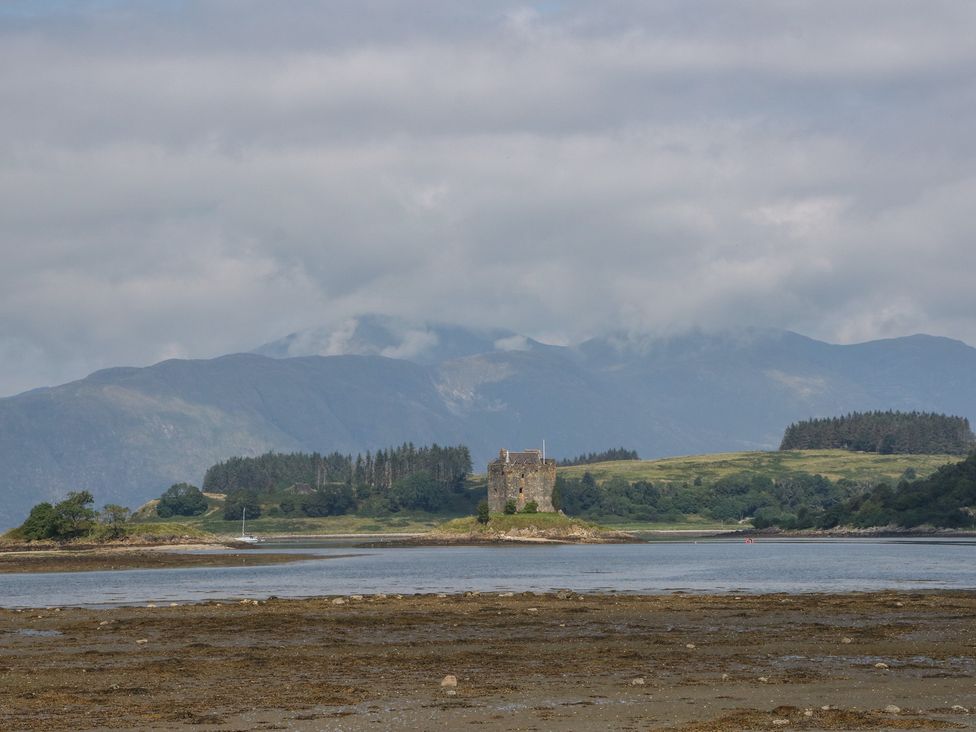 A castle on an island surrounded by water at Lurach House in Port Appin