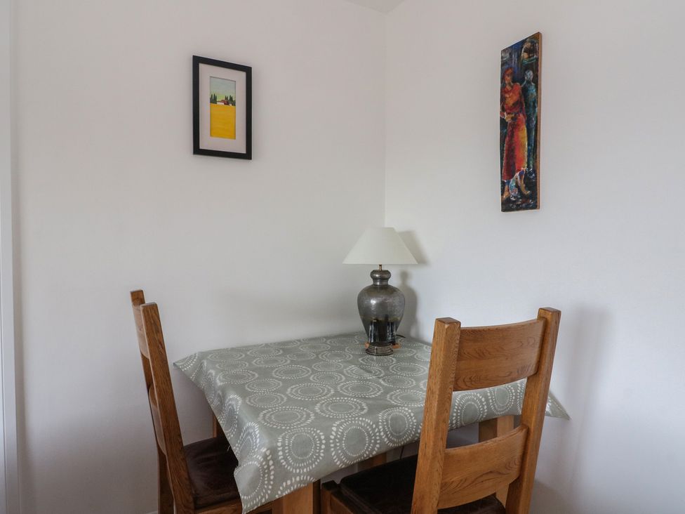A dining room with a table and lamp at Sealladh in Appin