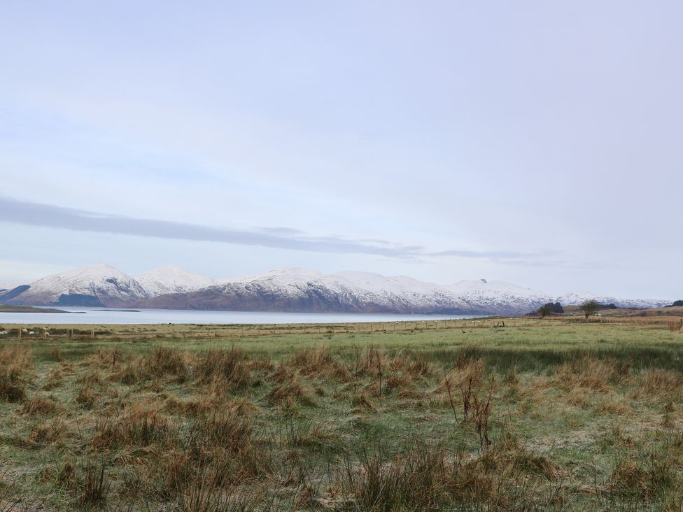 A landscape view of mountains and a lake with grassland in the foreground at Sealladh in Appin