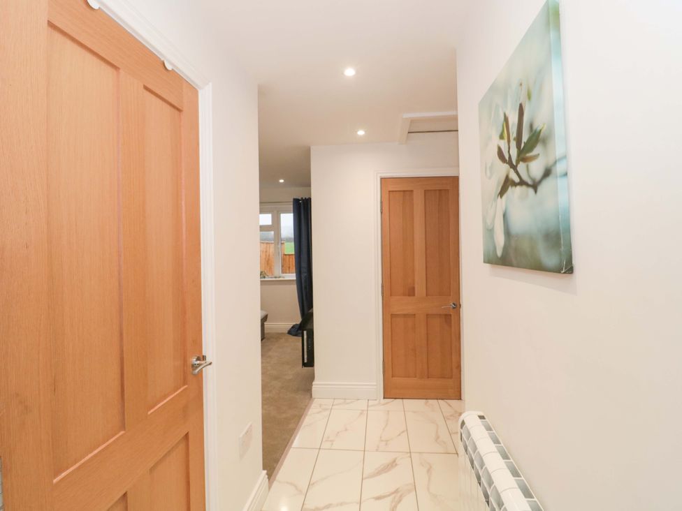 A hallway with doors and wall art at 2 Stroud Bungalows