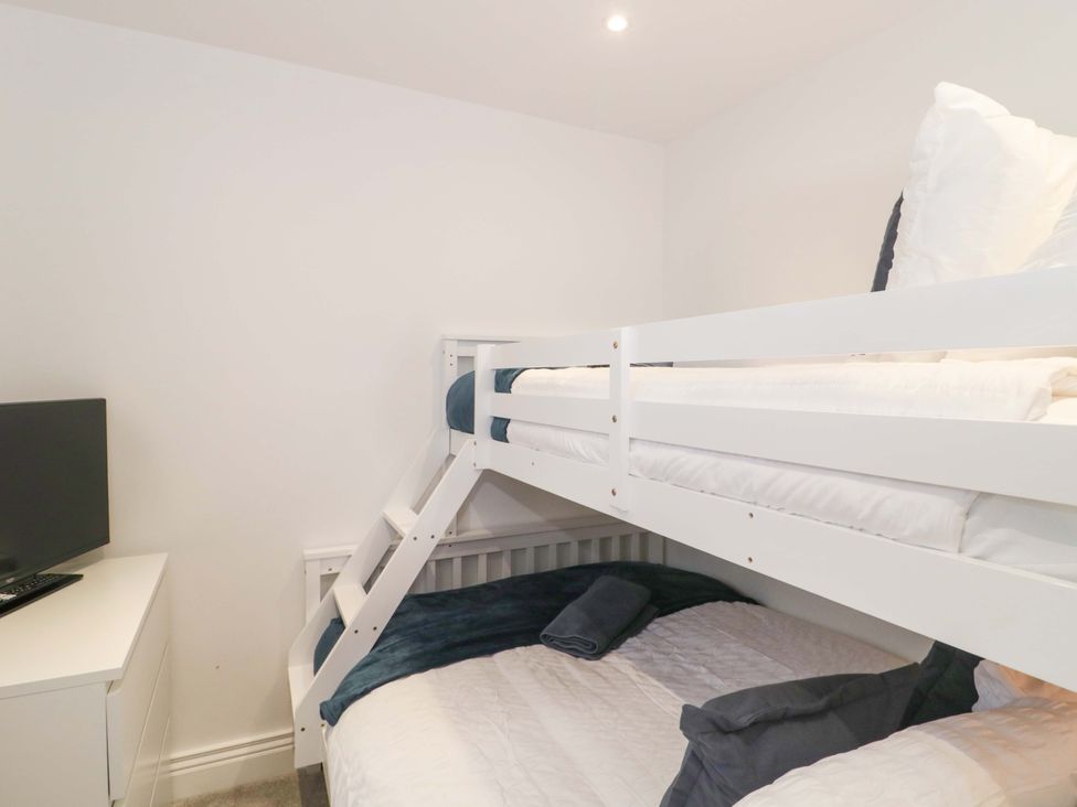 A bedroom with a bunk bed and a television at 2 Stroud Bungalows