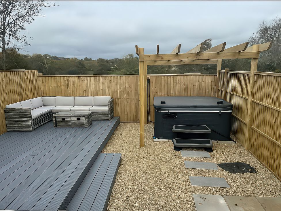 A garden with outdoor seating and hot tub at 2 Stroud Bungalows