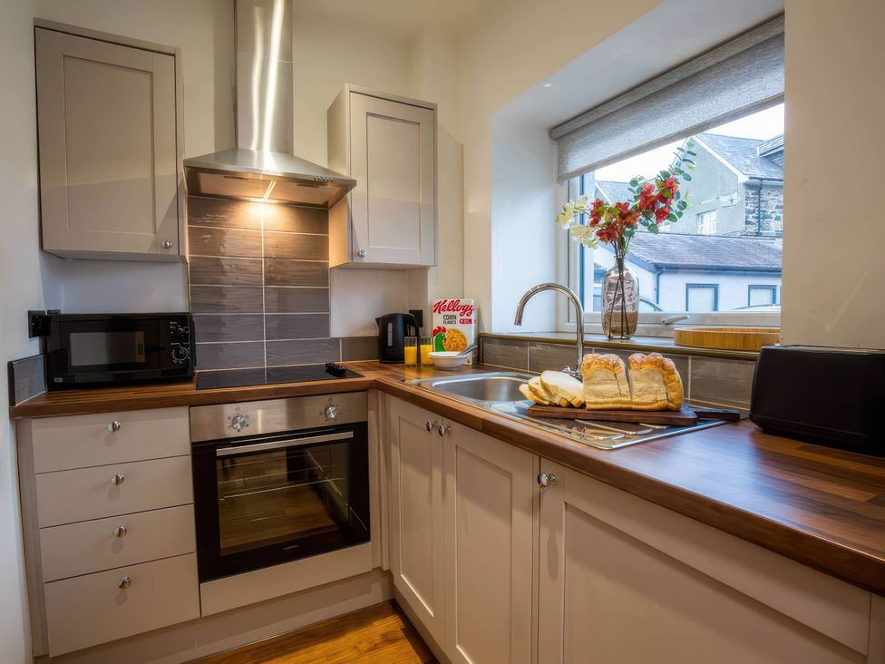 A kitchen with a sink and appliances at Aspen Apartment in Llanrwst
