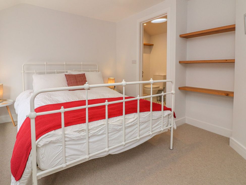 A bedroom with a bed and shelves at The Old Workshop