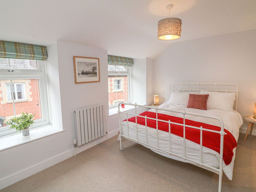 A bedroom with a bed and windows at The Old Workshop in 