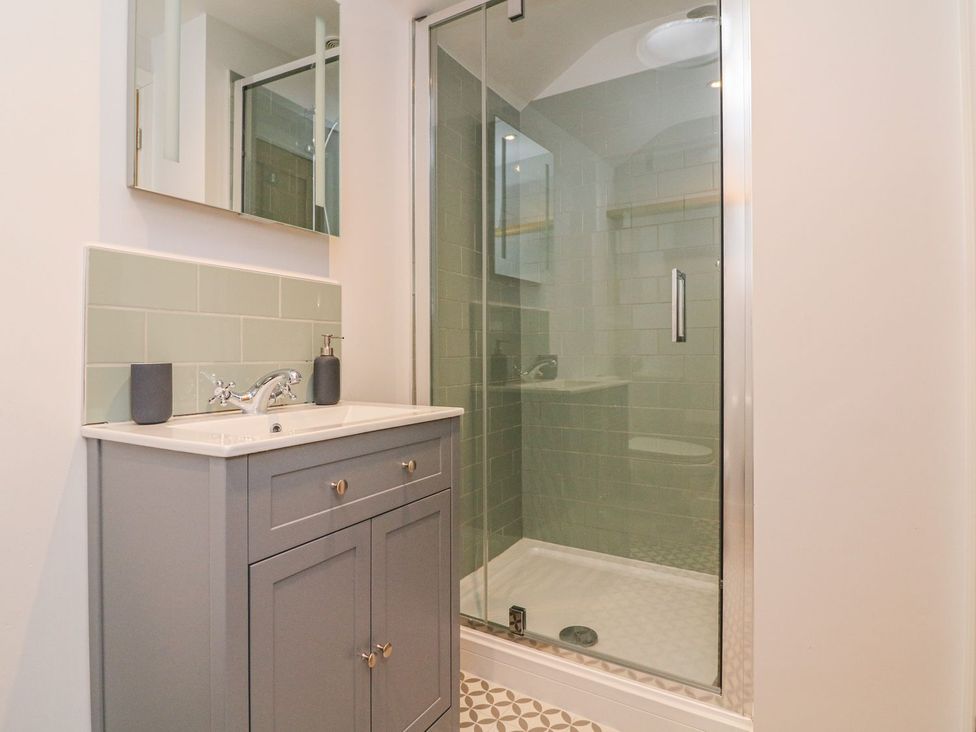 A bathroom with a sink and shower at The Old Workshop in 