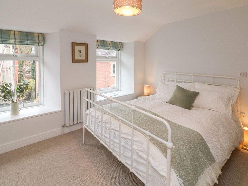 A bedroom with a bed and windows at The Old Workshop in 