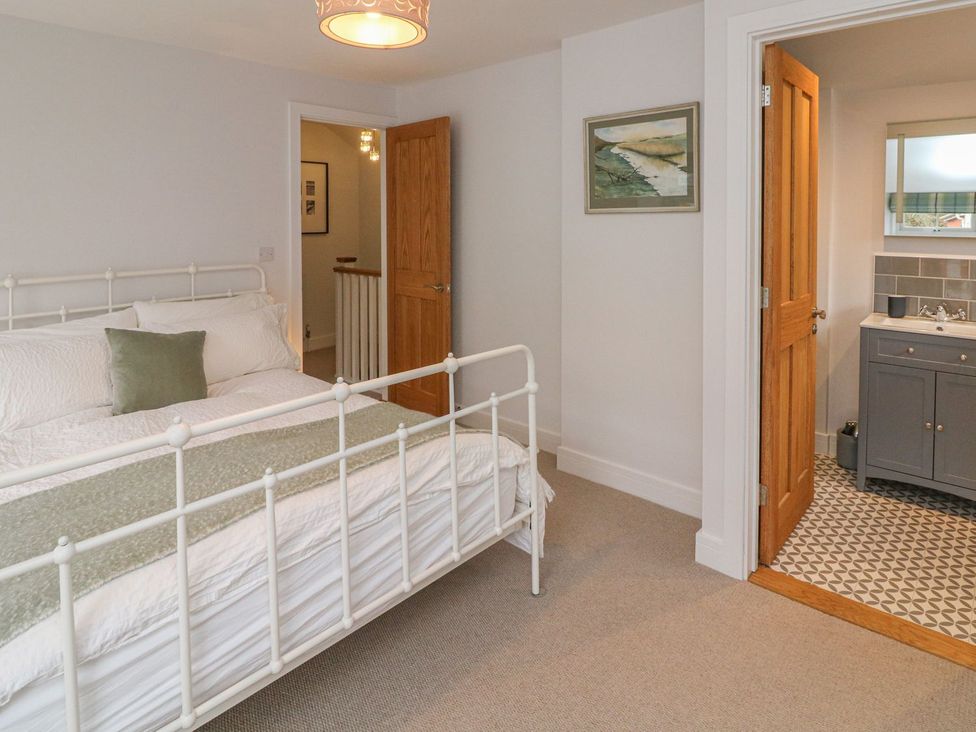 A bedroom featuring a bed and adjoining bathroom at The Old Workshop in 
