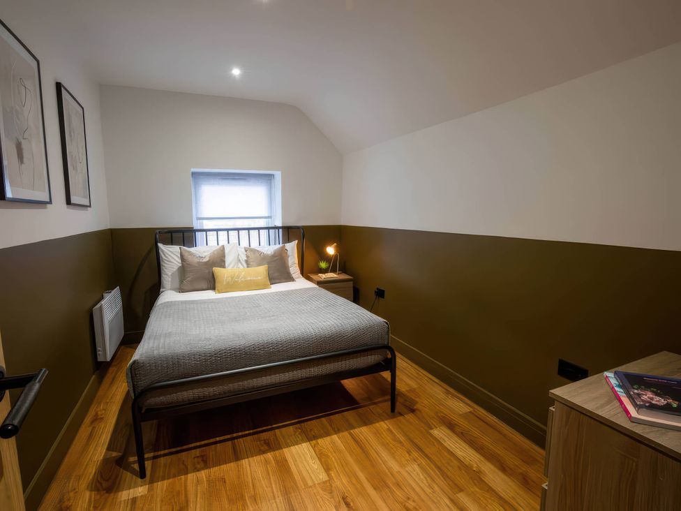 A bedroom with a bed and nightstand at White Willow Apartment Llanrwst