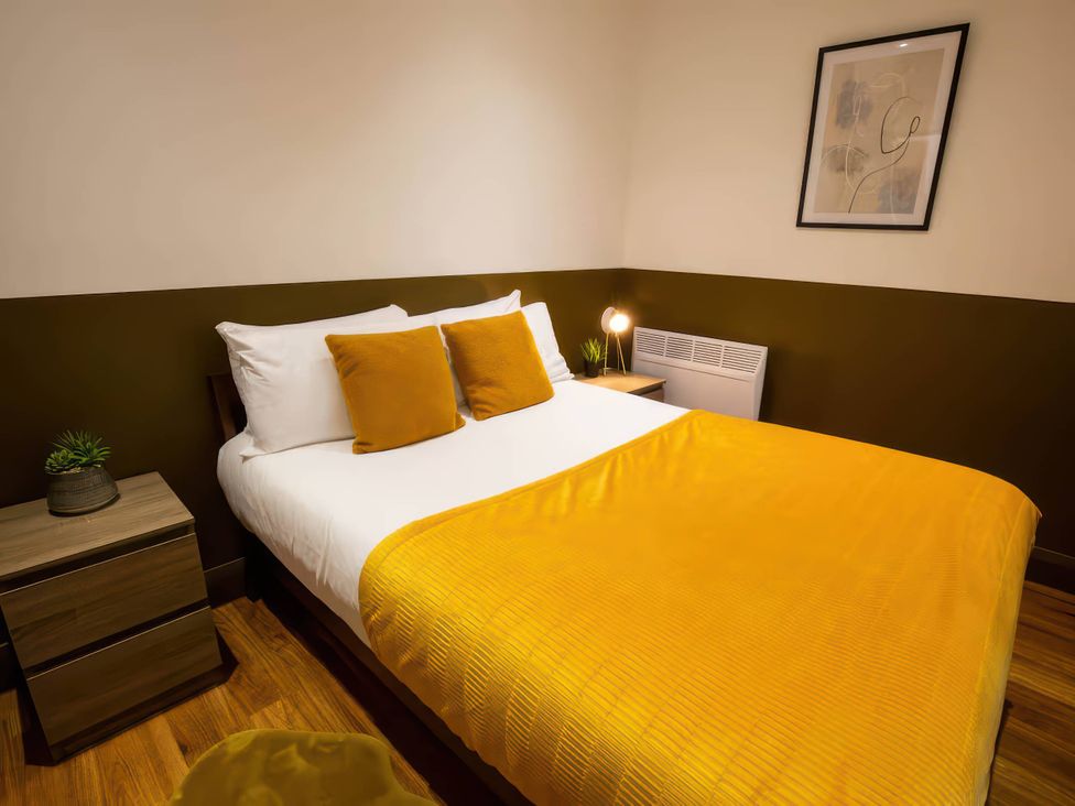 A bedroom with a bed and bedside table at Oakwood Apartment in Llanrwst