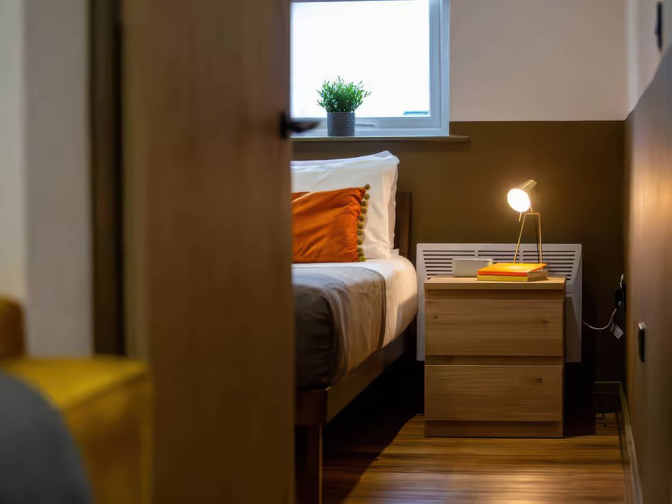 A bedroom with a bed and nightstand at Oakwood Apartment Llanrwst