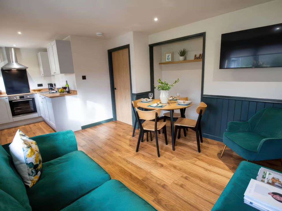 A living room with a kitchen and dining area at Ash Cottages in Llanrwst