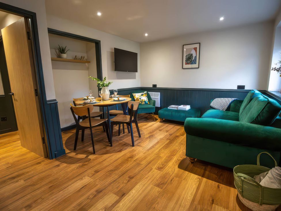 A living room with a dining table and sofa at Ash Cottages Llanrwst