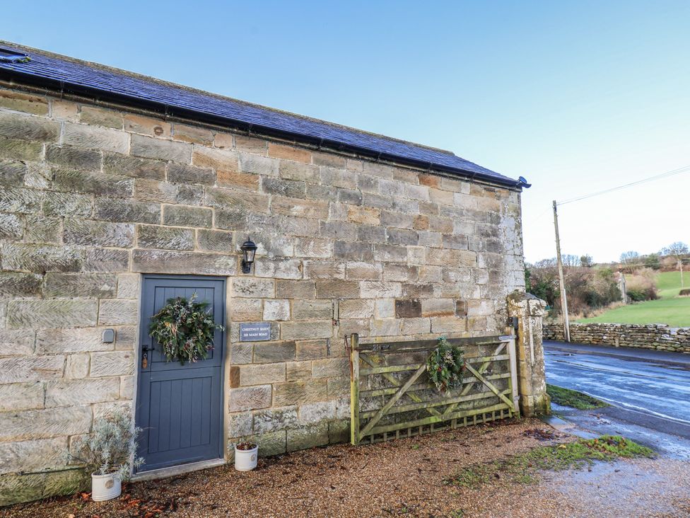An exterior view of a stone building with a door and a gate at Chestnut Barn in Aislaby near Whitby