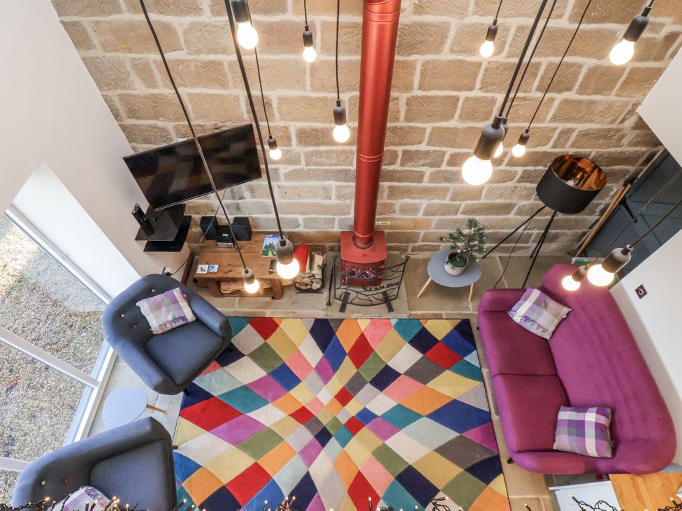 A living room with a colorful rug and seating area at Chestnut Barn Aislaby near Whitby