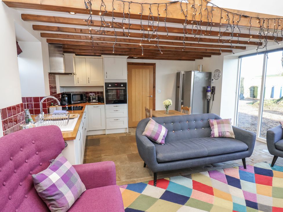 A kitchen with a sofa and armchair in Chestnut Barn Aislaby near Whitby
