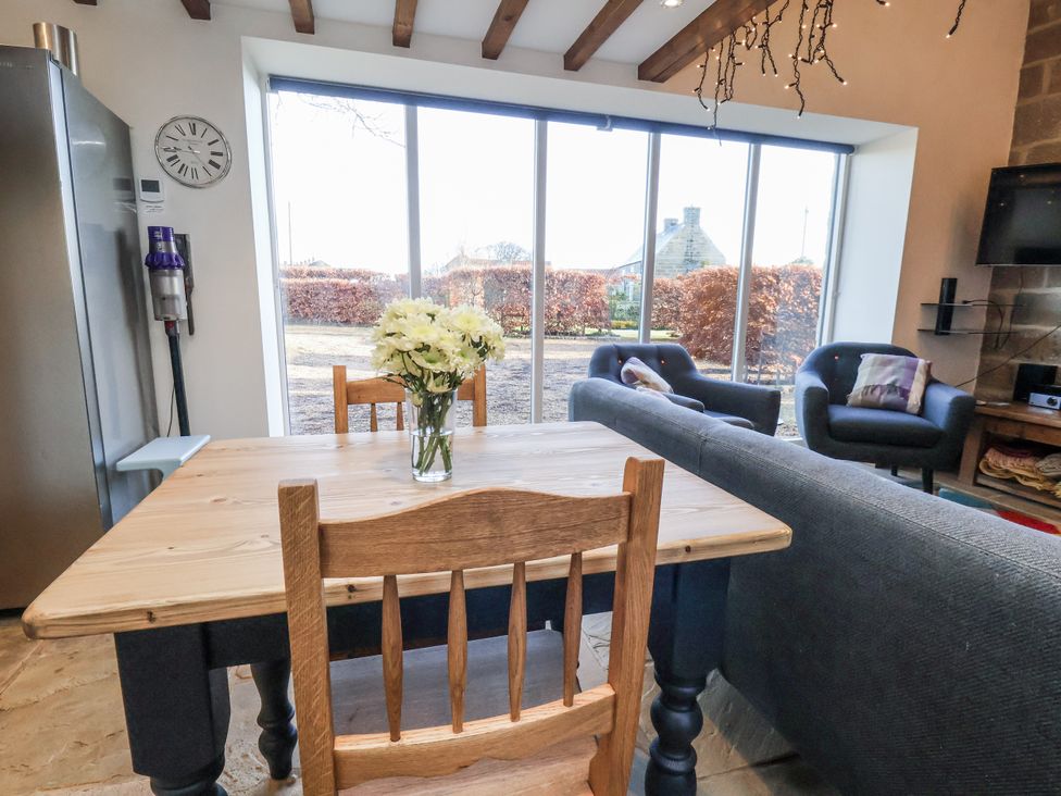 A dining room with a table and chairs at Chestnut Barn Aislaby near Whitby