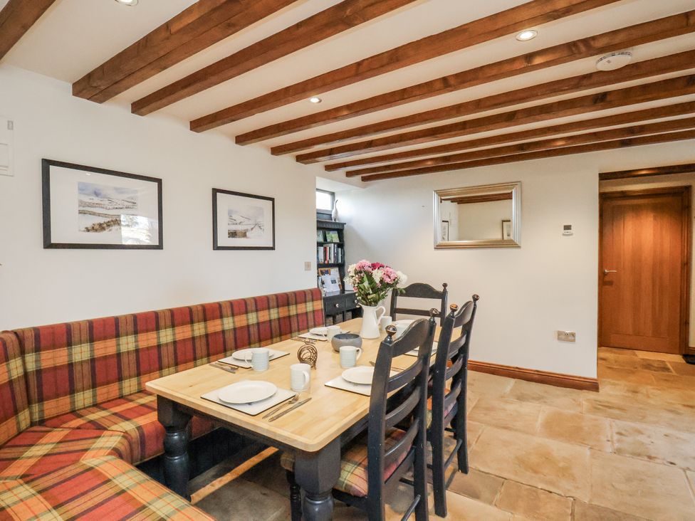 A dining room with a table and chairs at Chestnut Barn Aislaby near Whitby