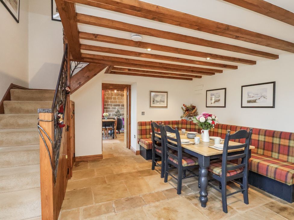 A dining room with a table and chairs at Chestnut Barn Aislaby near Whitby