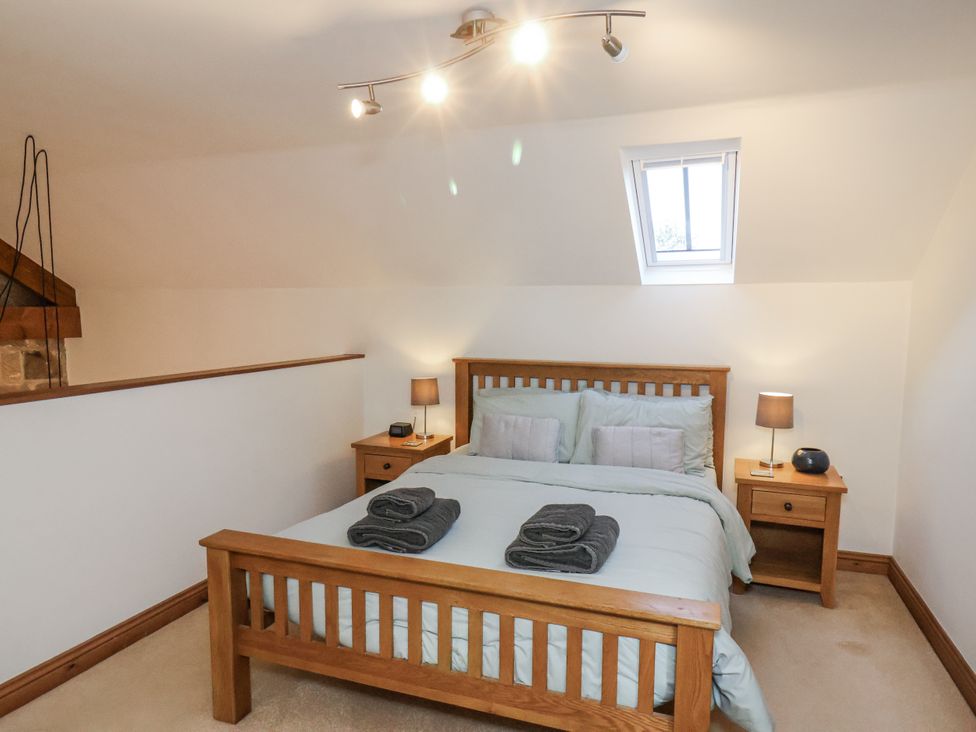 A bedroom with a bed and nightstands at Chestnut Barn Aislaby near Whitby