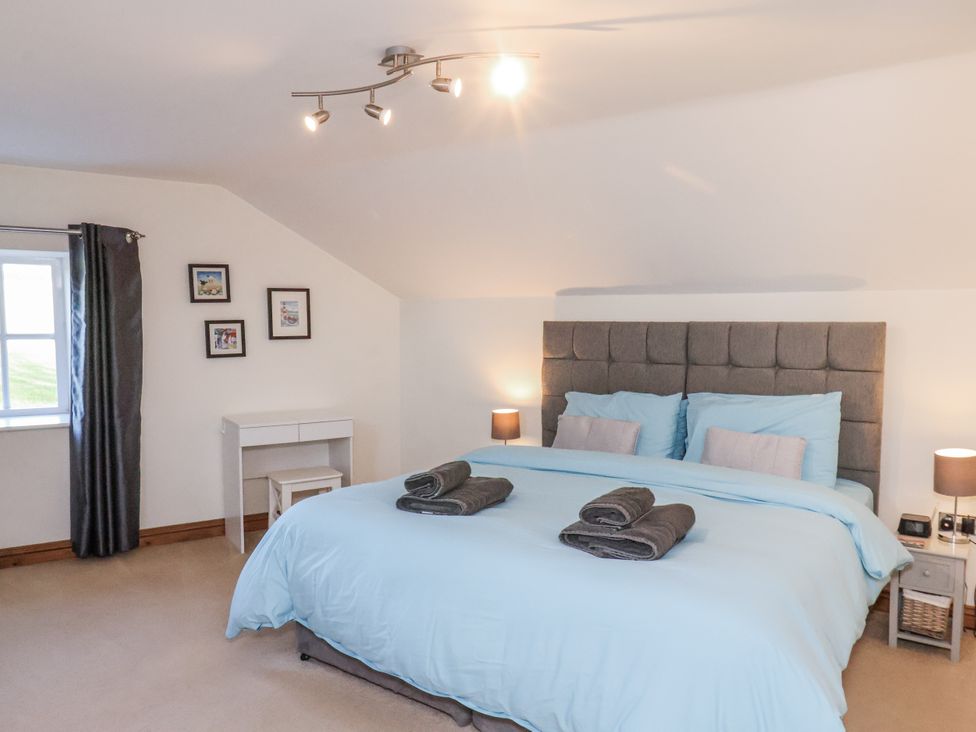 A bedroom with a bed and bedside tables at Chestnut Barn Aislaby near Whitby
