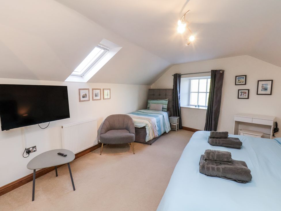 A bedroom with two beds and a television at Chestnut Barn Aislaby near Whitby