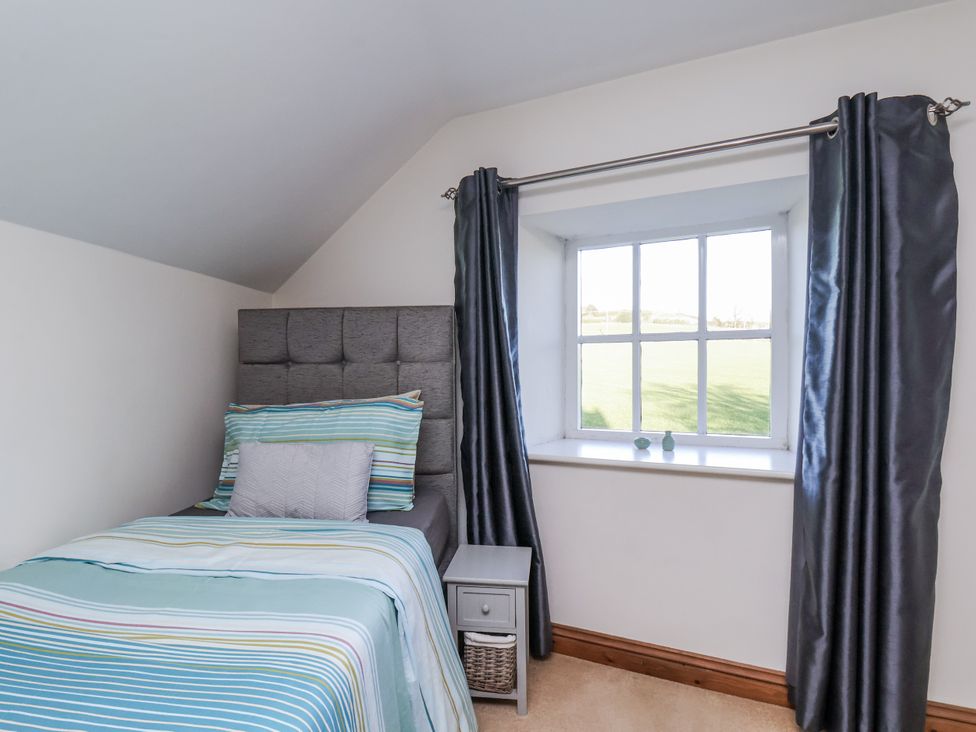 A bedroom with a bed and window at Chestnut Barn Aislaby near Whitby
