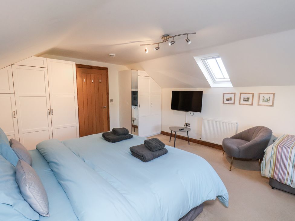 A bedroom with a bed and television at Chestnut Barn in Aislaby near Whitby