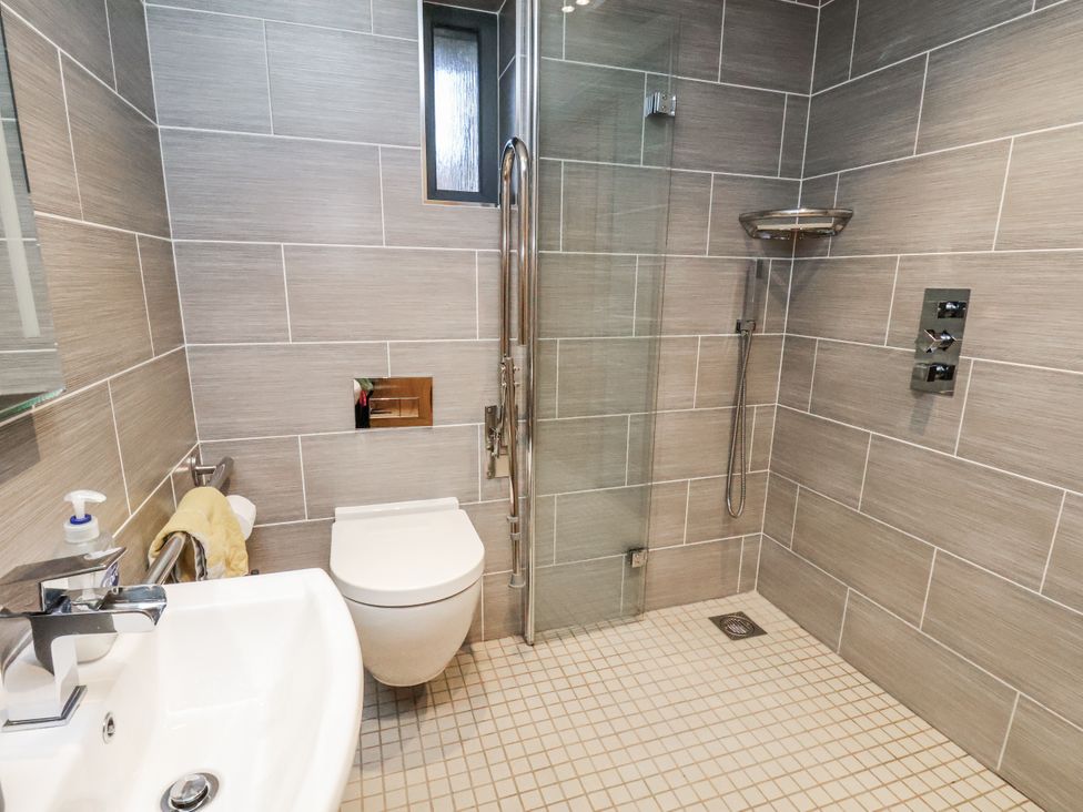 A bathroom with a sink, toilet, and shower at Chestnut Barn Aislaby near Whitby