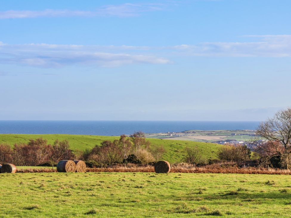 A landscape with hills and hay bales near the ocean at Chestnut Barn Aislaby near Whitby