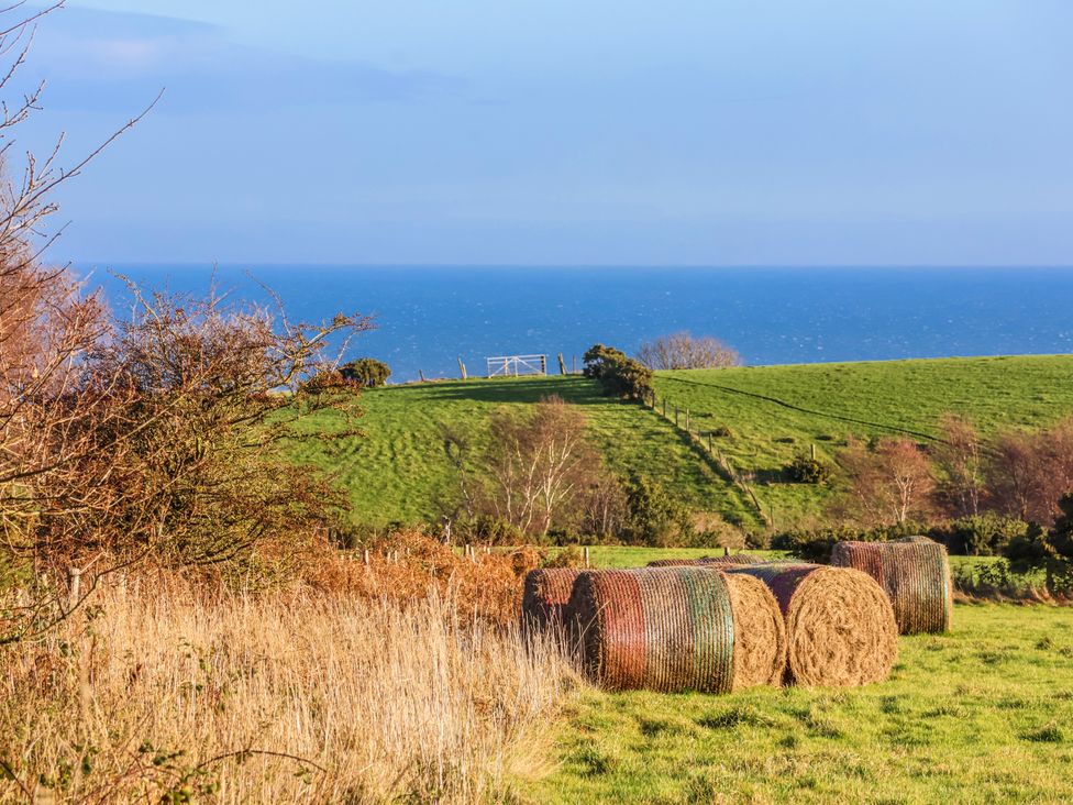 A view of hay bales on grass with the sea in the background at Chestnut Barn Aislaby near Whitby