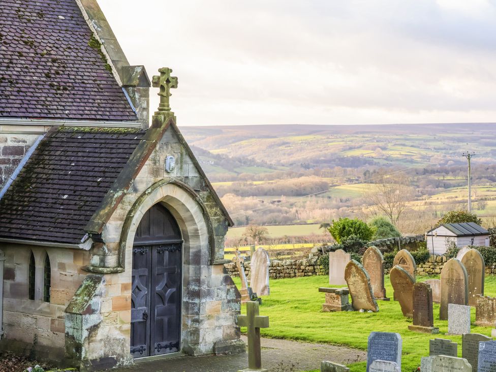 A church near a graveyard overlooking hills at Chestnut Barn in Aislaby near Whitby