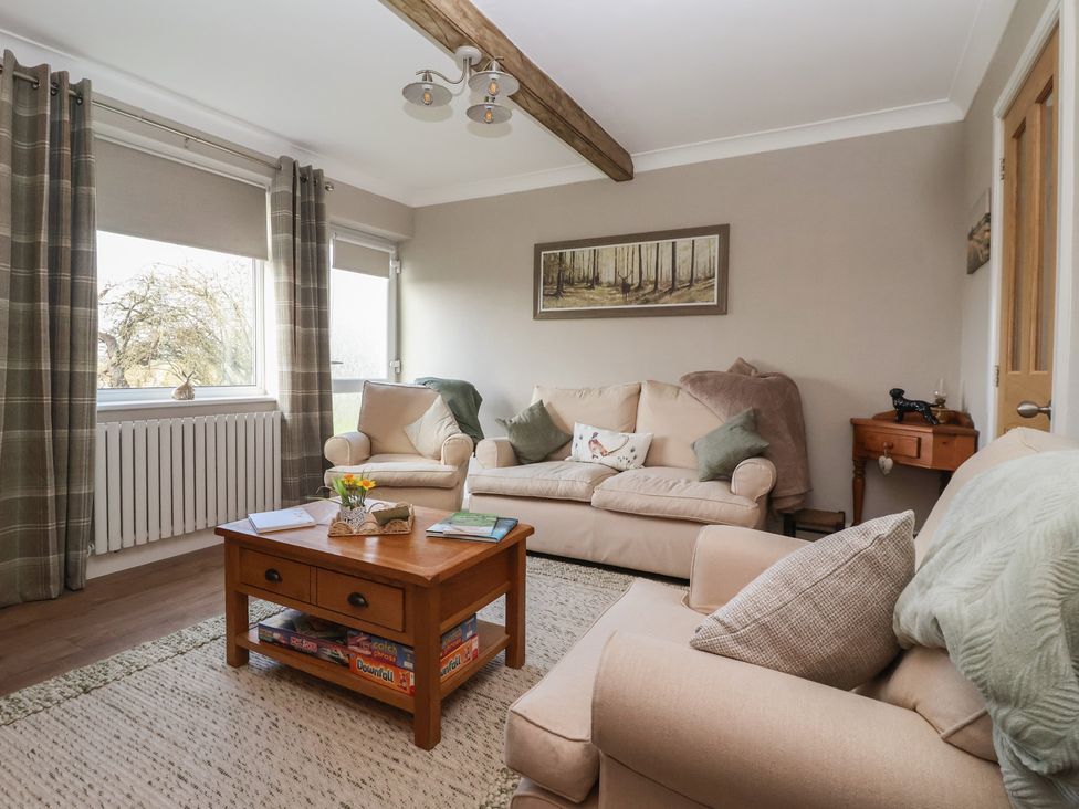 A living room with a sofa and coffee table at Daffodil Cottage in York