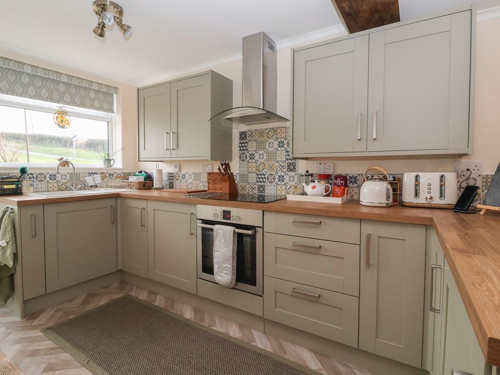 A kitchen with cabinets and appliances at Daffodil Cottage in York