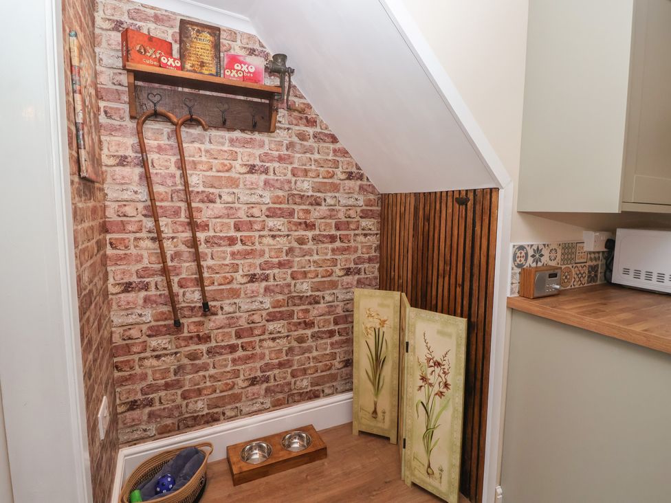 A corner with a shelf and dog bowls at Daffodil Cottage in York