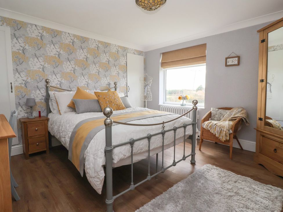 A bedroom with a bed and bedside table at Daffodil Cottage in York