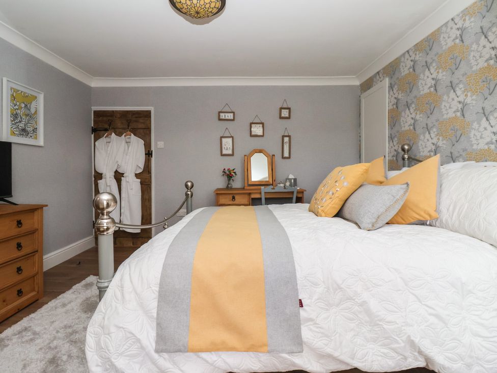 A bedroom with a bed and dresser at Daffodil Cottage in York