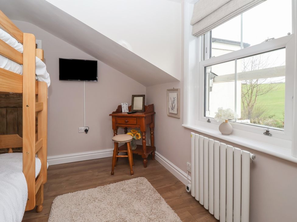 A bedroom with a bunk bed and a side table at Daffodil Cottage in York