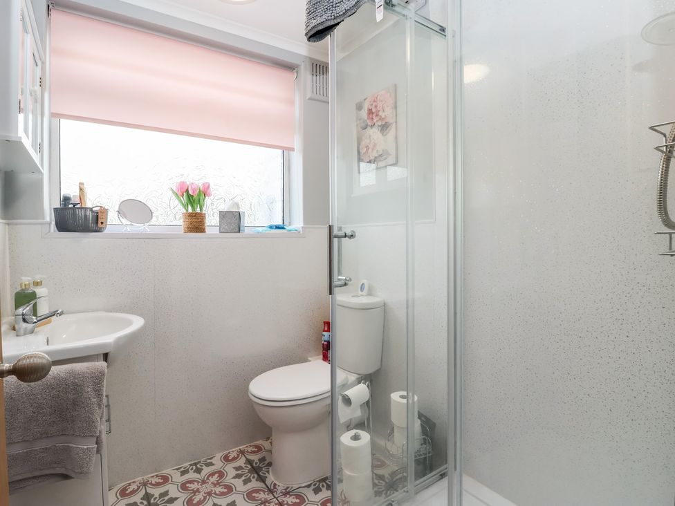 A bathroom with a sink, toilet, and shower at Daffodil Cottage in York