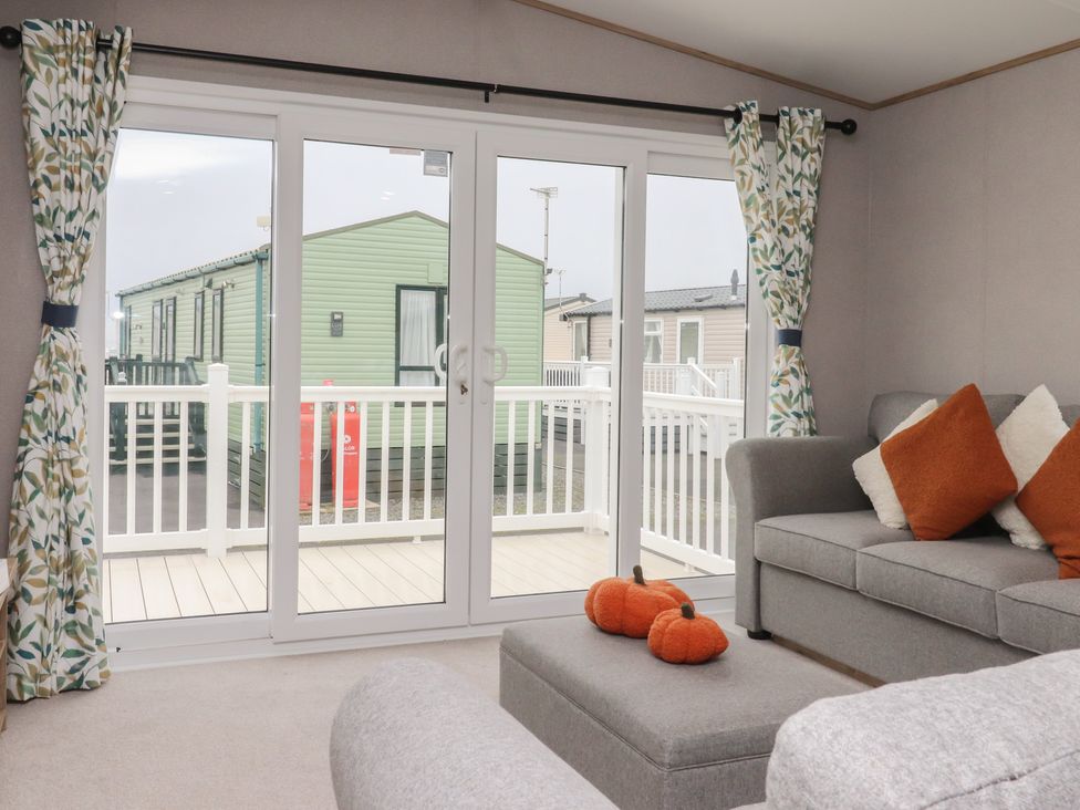 A living room with sliding doors and a sofa at The Retreat in Morecambe